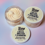 Up and Glow Cocoa Butter Cashmere magnesium body butter with lid on a white background