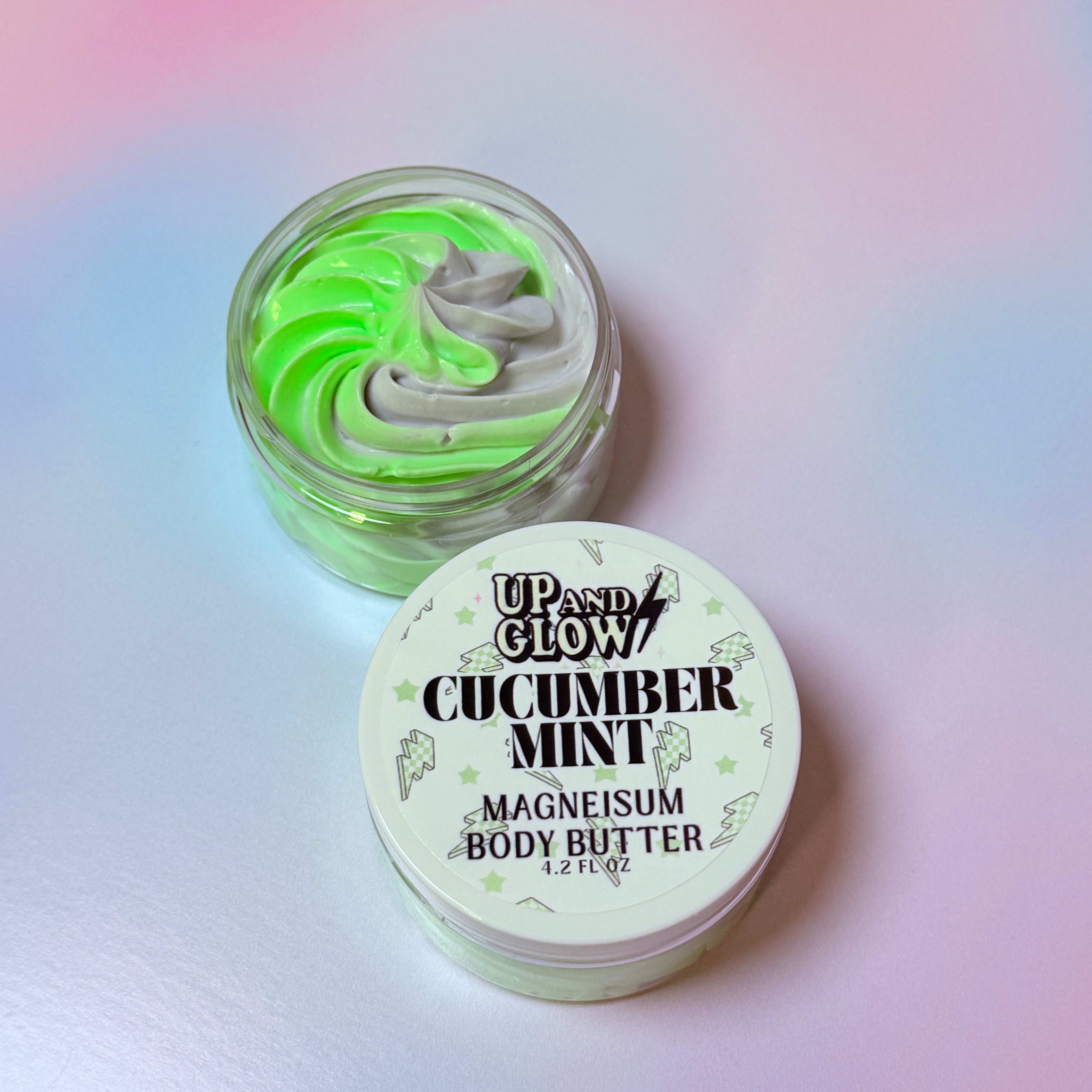 Cucumber mint body butter jar with green and white swirls on a gradient background