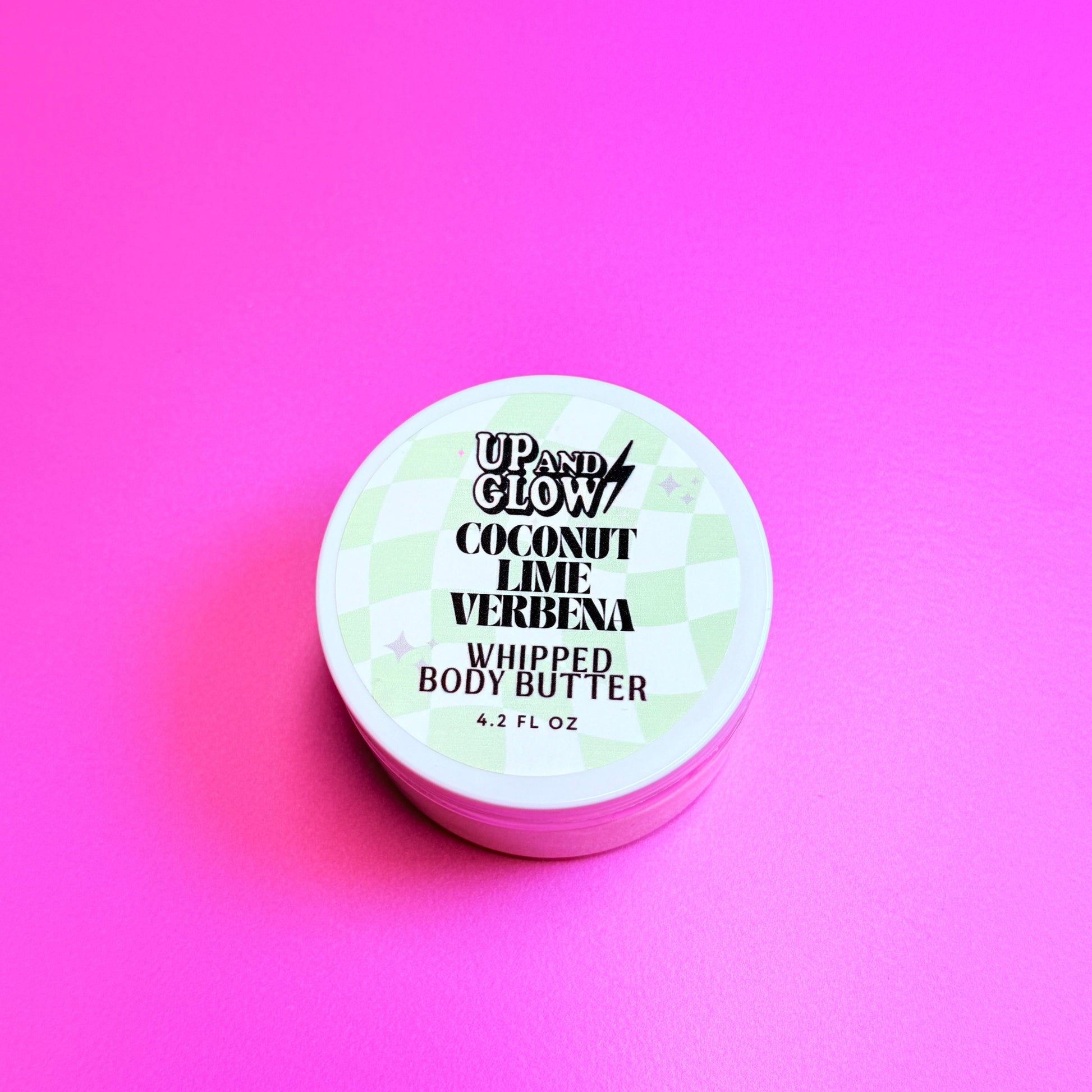 Up and Glow coconut lime verbena whipped body butter container on a pink background