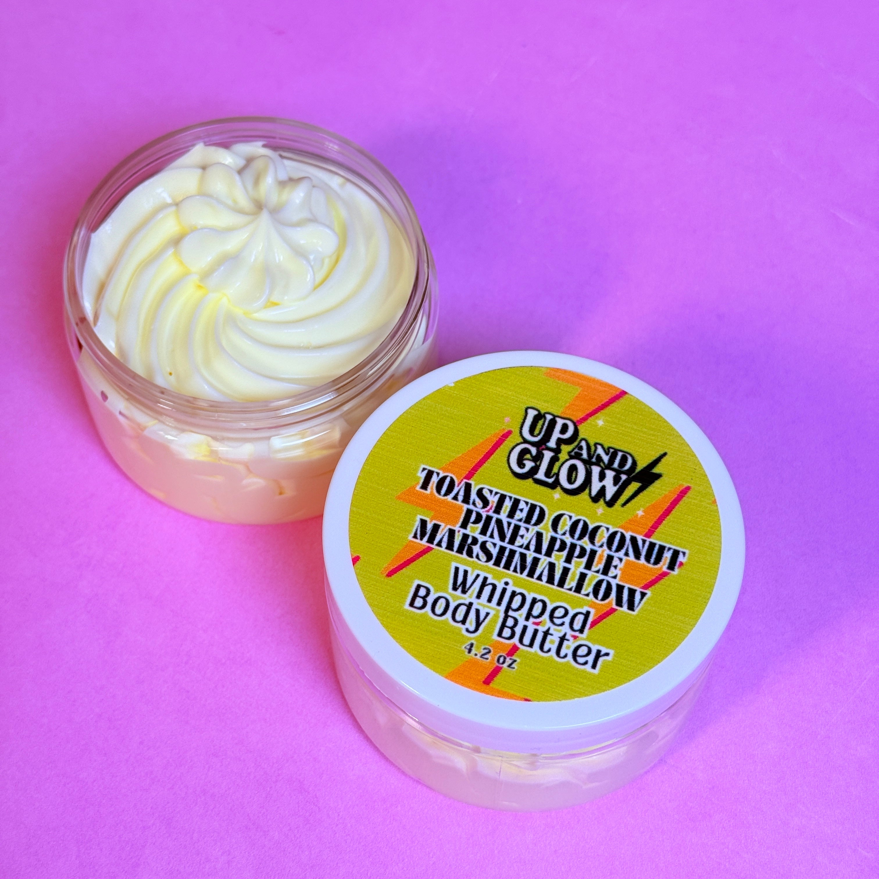 Jar of whipped body butter with a colorful label on a pink background